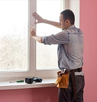 Contractor installing replacement window in home interior