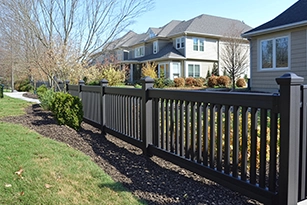 Black residential privacy fence installation along yard