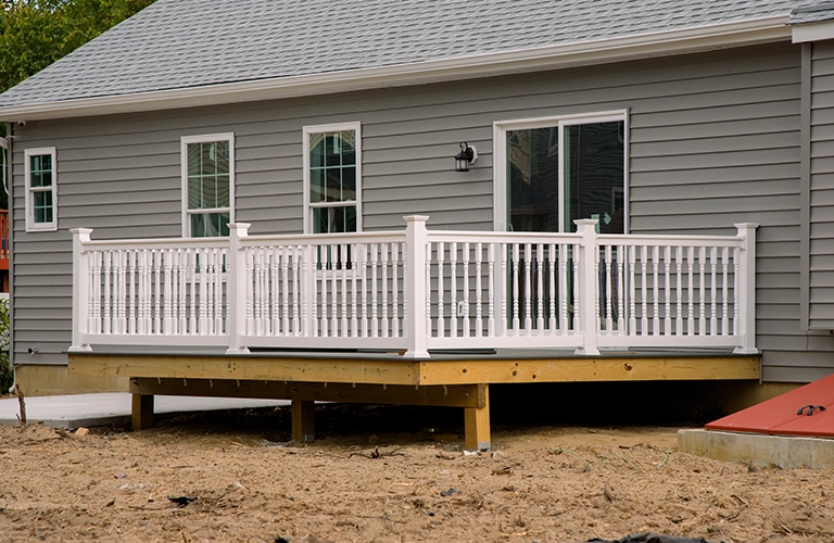 New residential deck with white railing installation