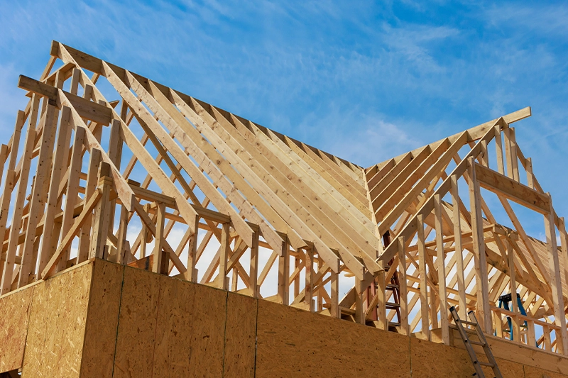 Construction manager reviewing house plans at a framing stage residential jobsite